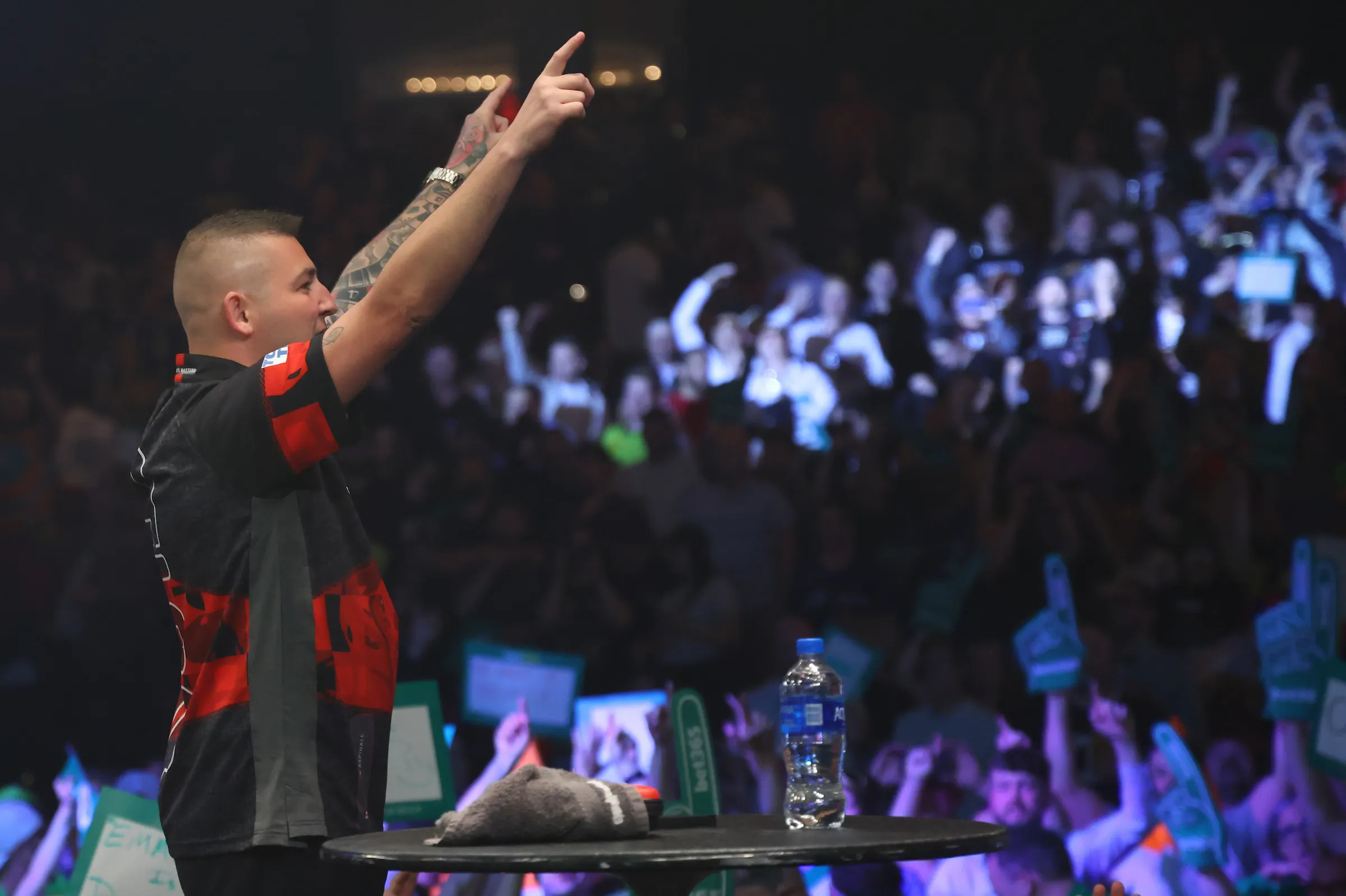 A player celebrating in front of a packed US Darts Masters crowd